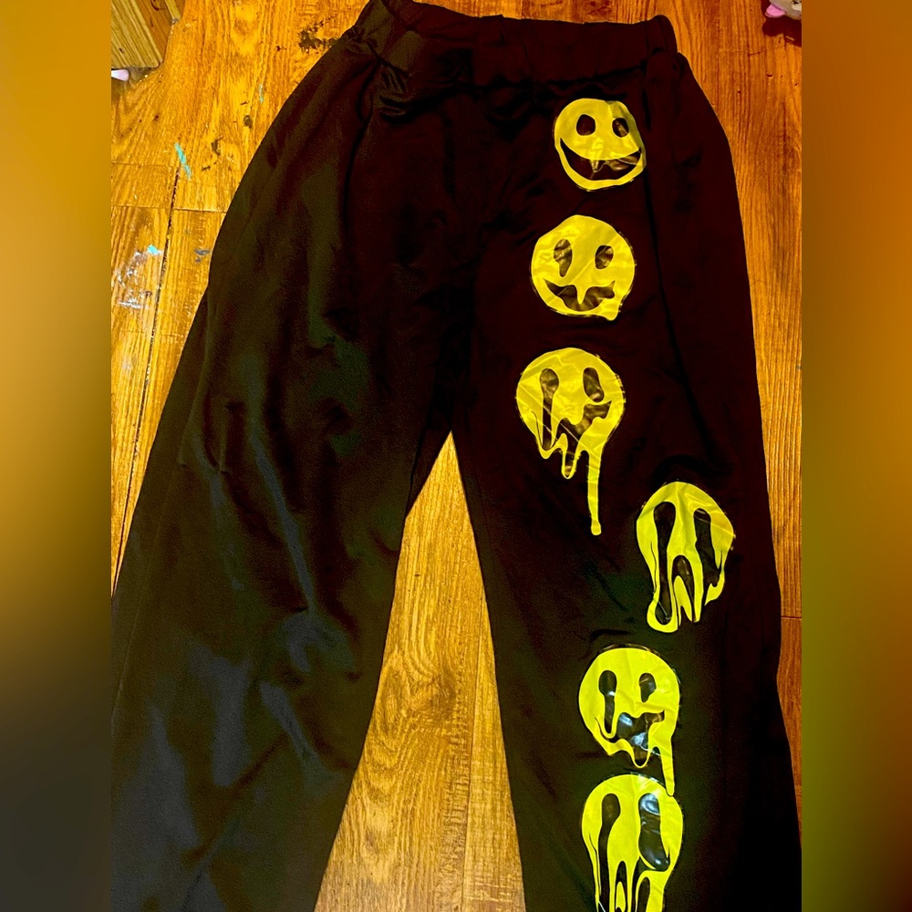Cute black sweatpants with smiley faces on the left side.